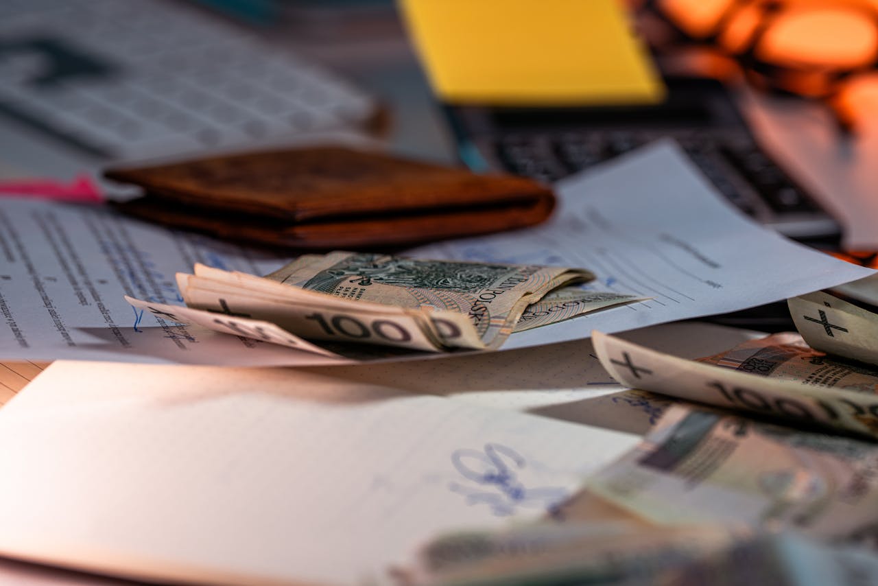 services-02 Zloty banknotes and financial paperwork scattered on a desk, representing budgeting and finance.