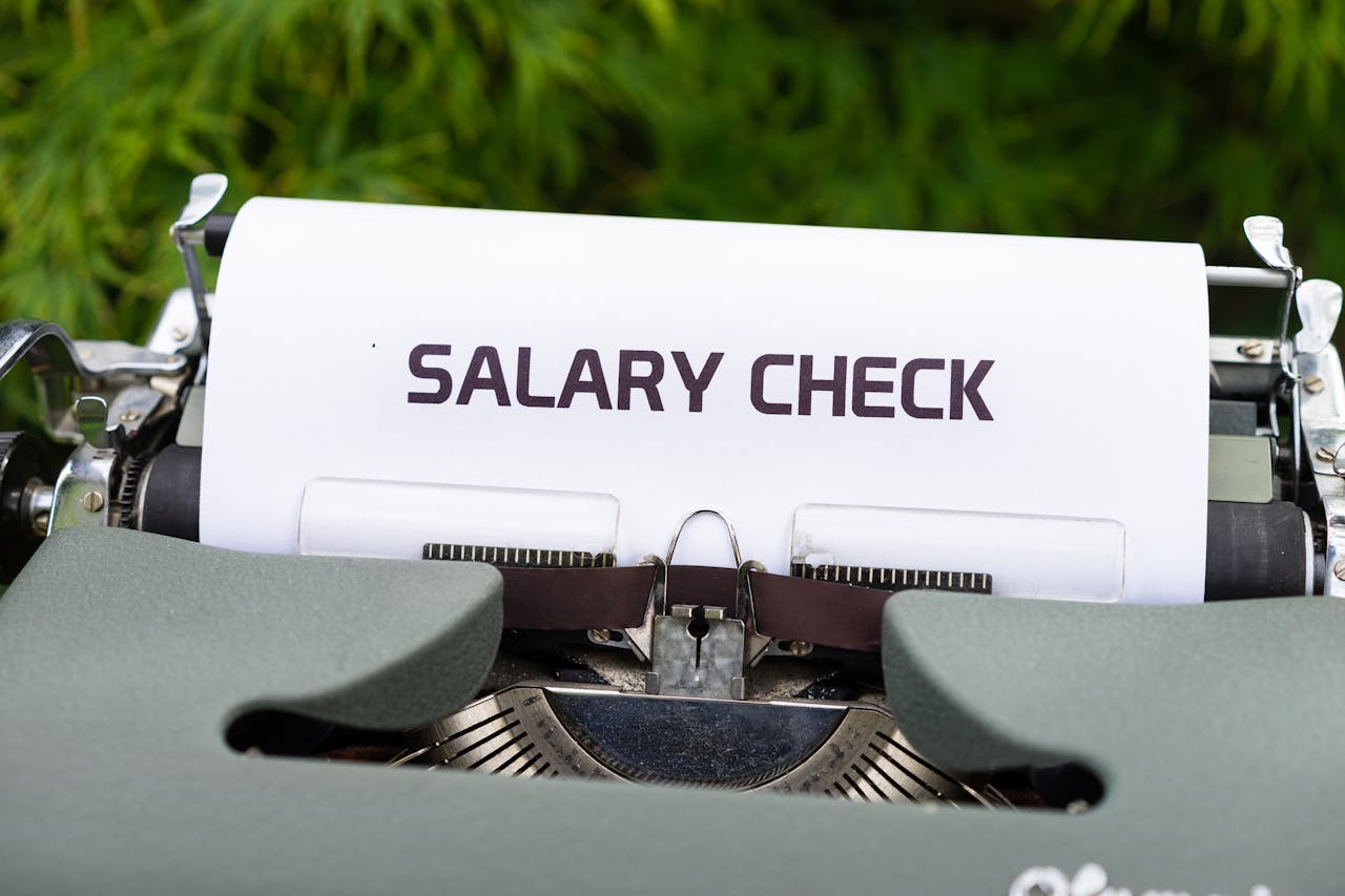 Close-up of a vintage typewriter typing Salary Check on paper, symbolizing payroll and finance.
